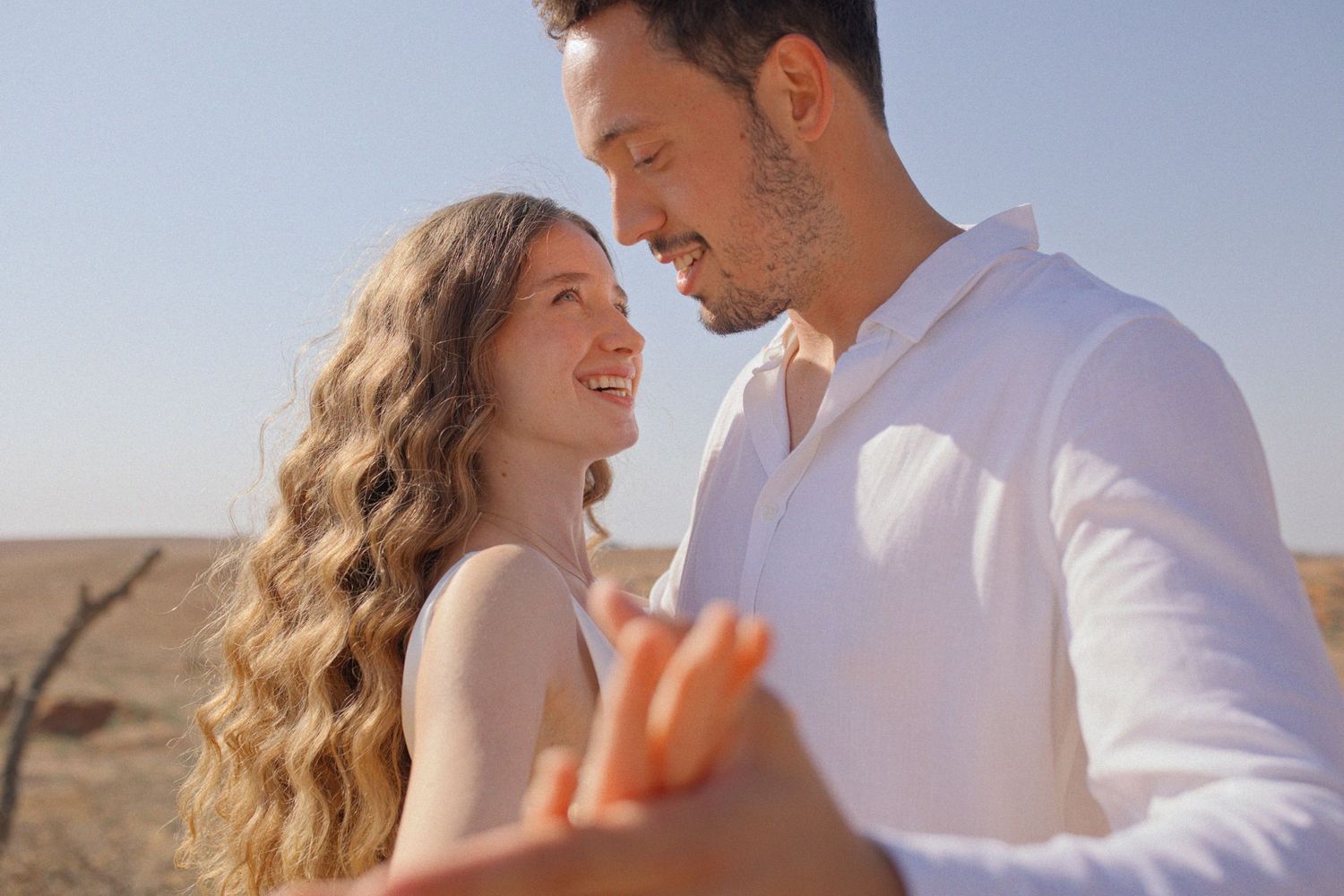 Romantic couple photoshoot in a desert landscape during golden hour.