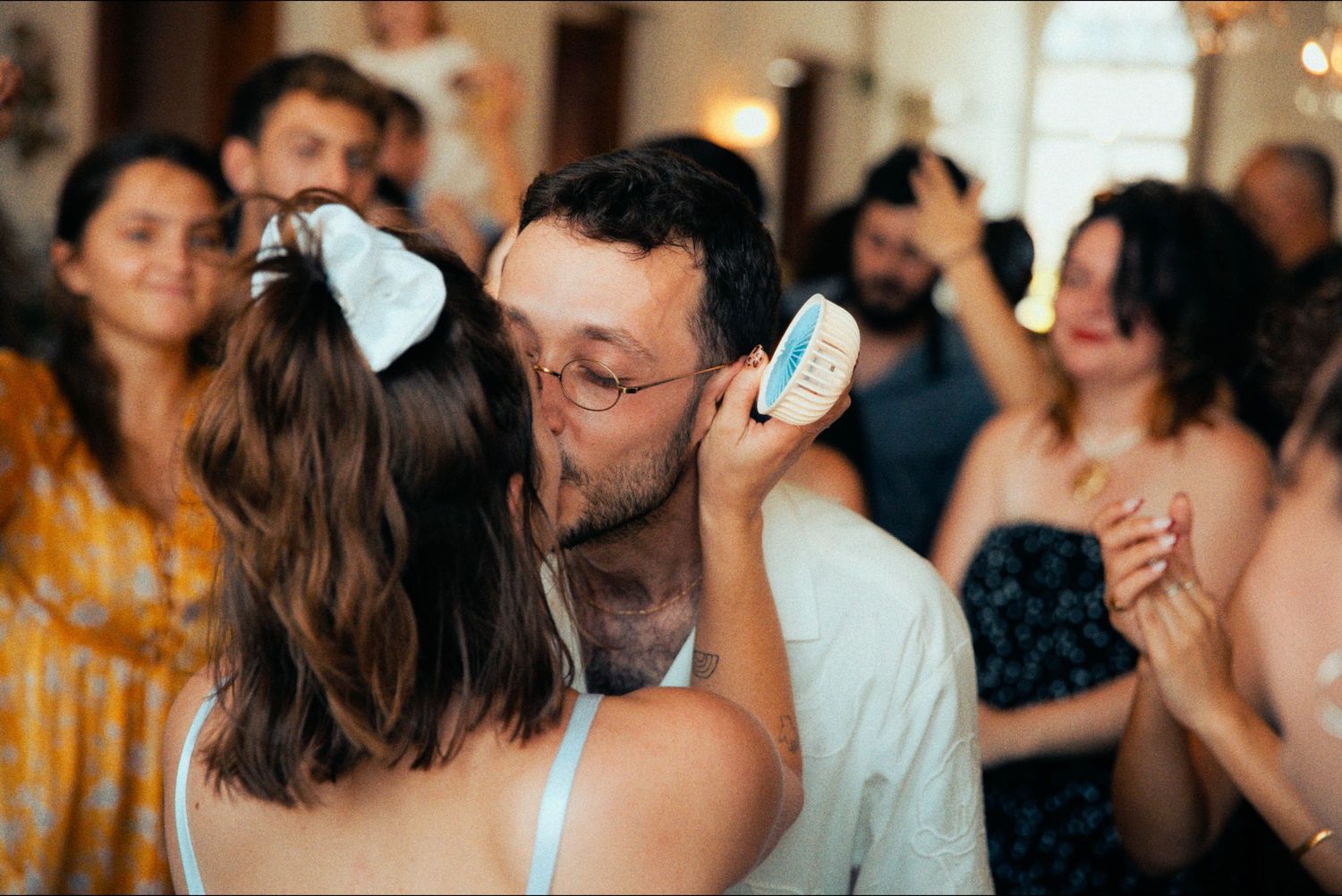 Wedding reception guests dancing and celebrating in an elegant indoor venue.