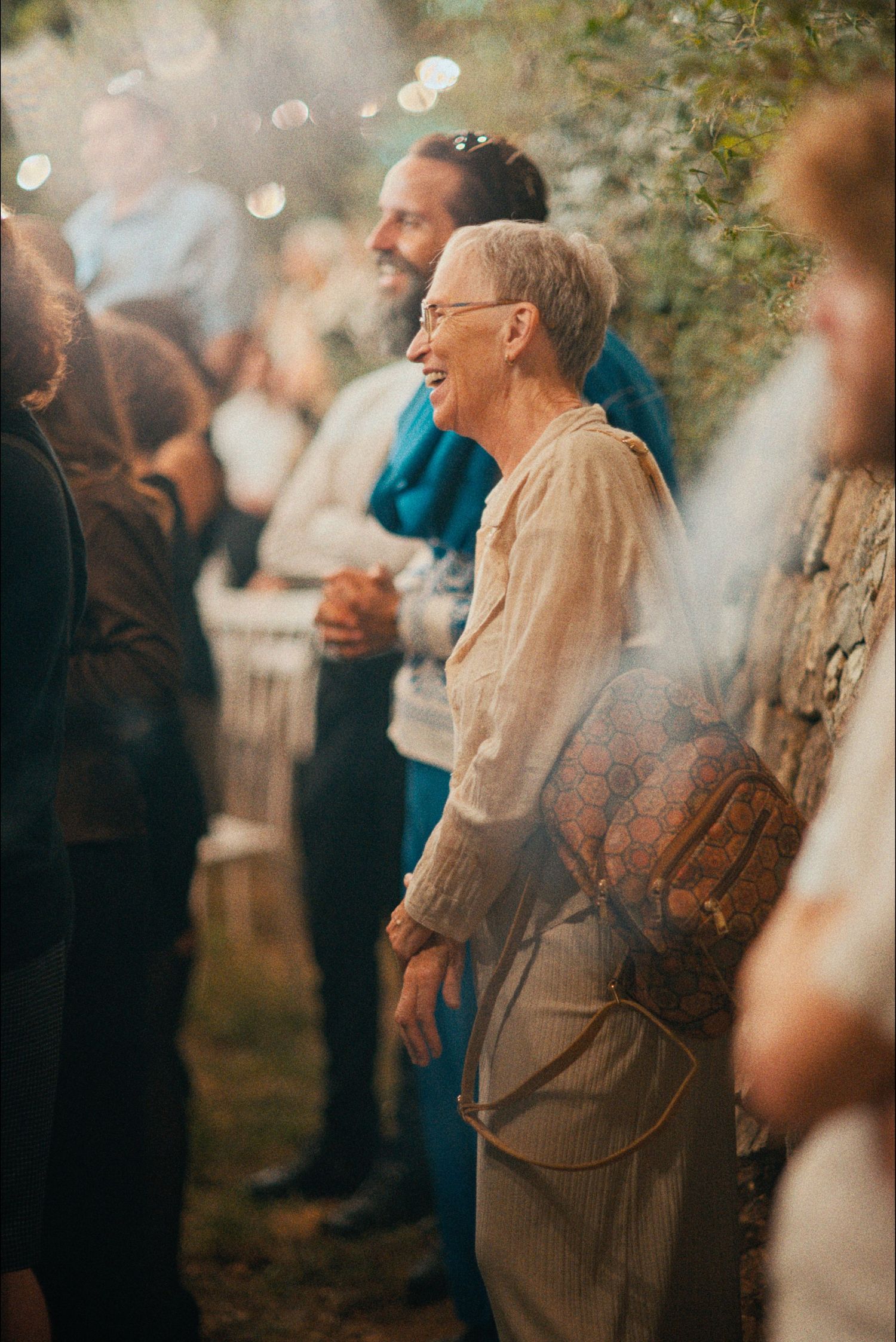 Guests enjoy a festive outdoor celebration with string lights creating a warm ambiance.