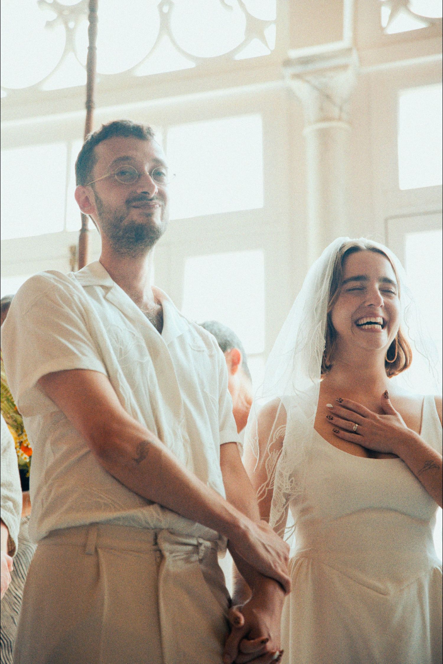 Dancing couple sharing a joyful moment in white attire.