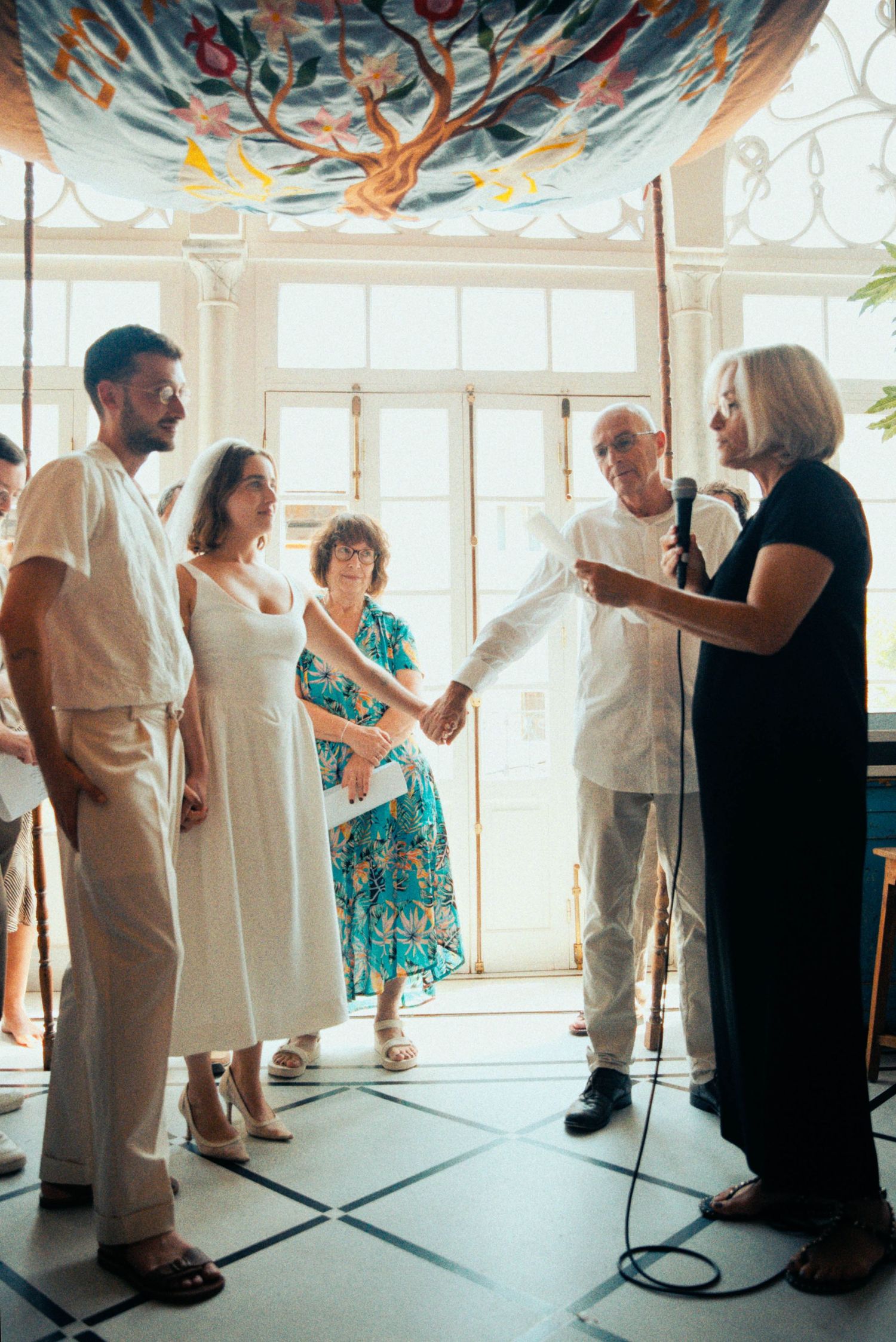 Group of wedding guests gathered in a bright room with blue and orange decorative elements.