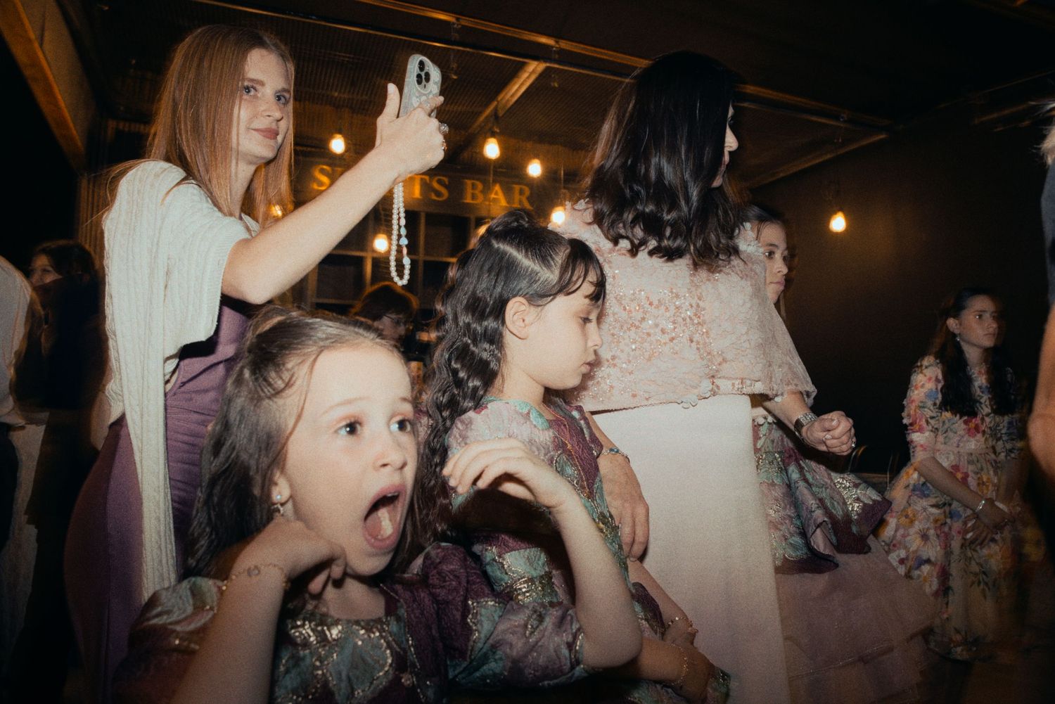 Candid moment of party guests reacting with excitement during a celebration.