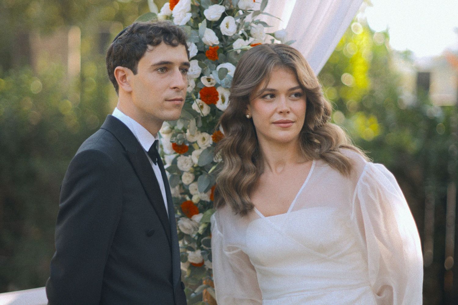 Wedding couple shares intimate moments during sunset outdoor celebration with floral decorations.