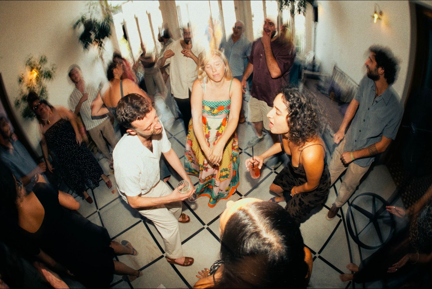 Guests dancing and celebrating at an indoor party with atmospheric lighting.