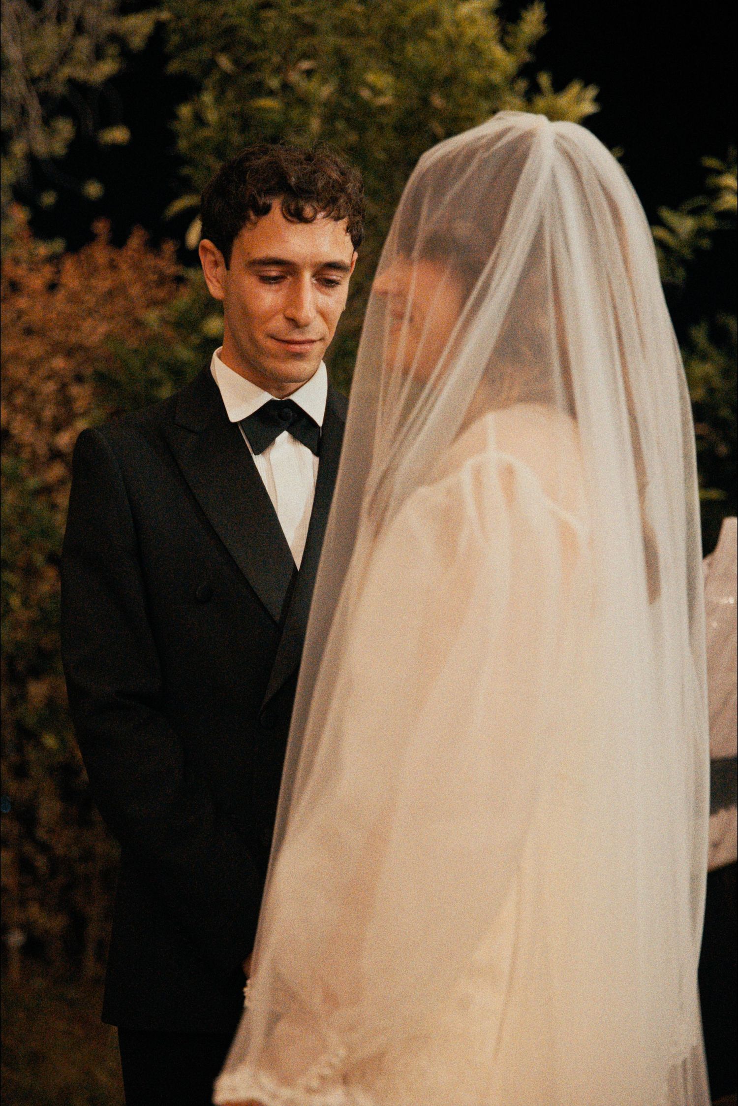 A romantic wedding moment captured in warm lighting during an outdoor ceremony.