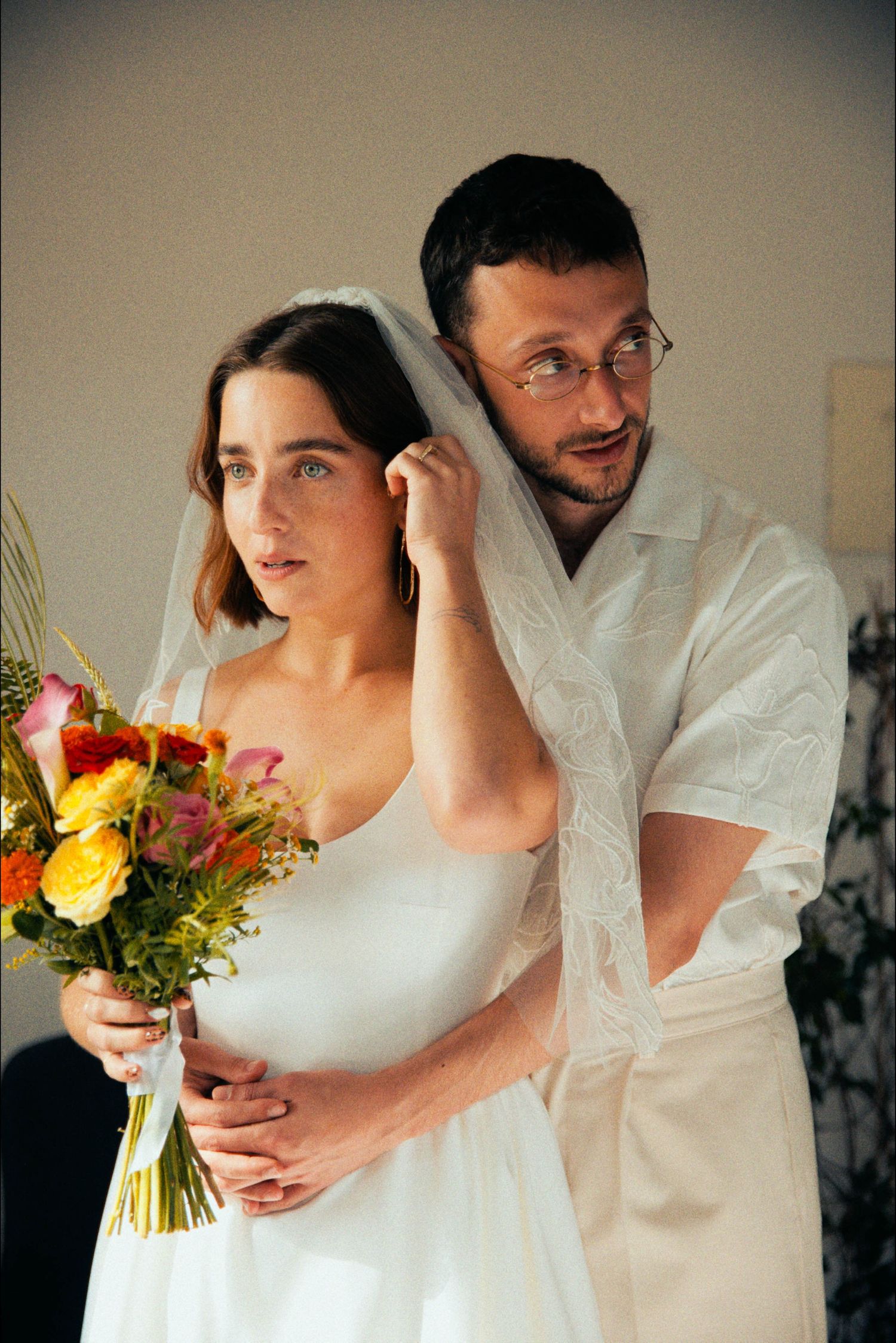 A series of intimate wedding photos featuring a bouquet of colorful flowers.