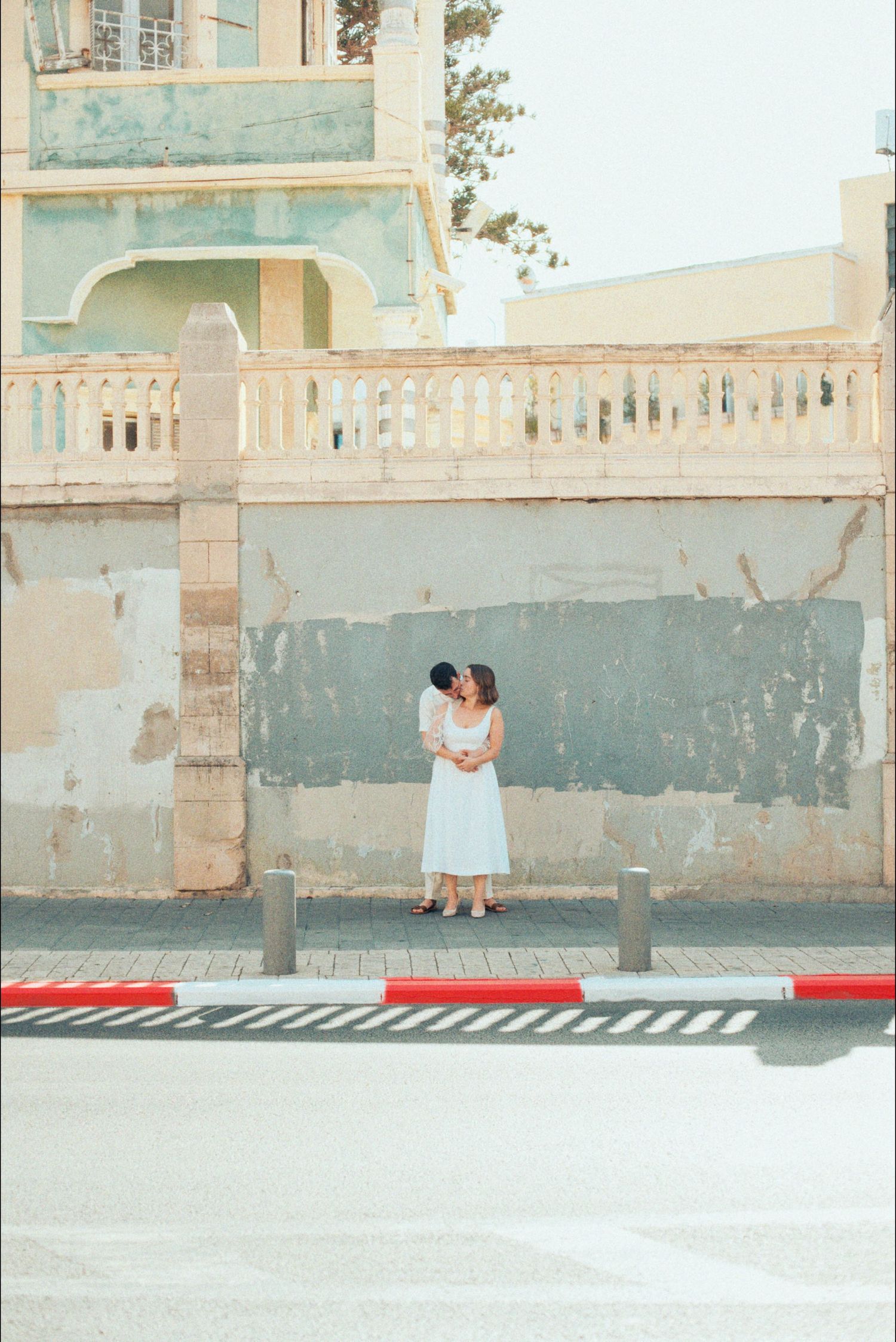 A romantic outdoor scene against a weathered wall with soft natural lighting.