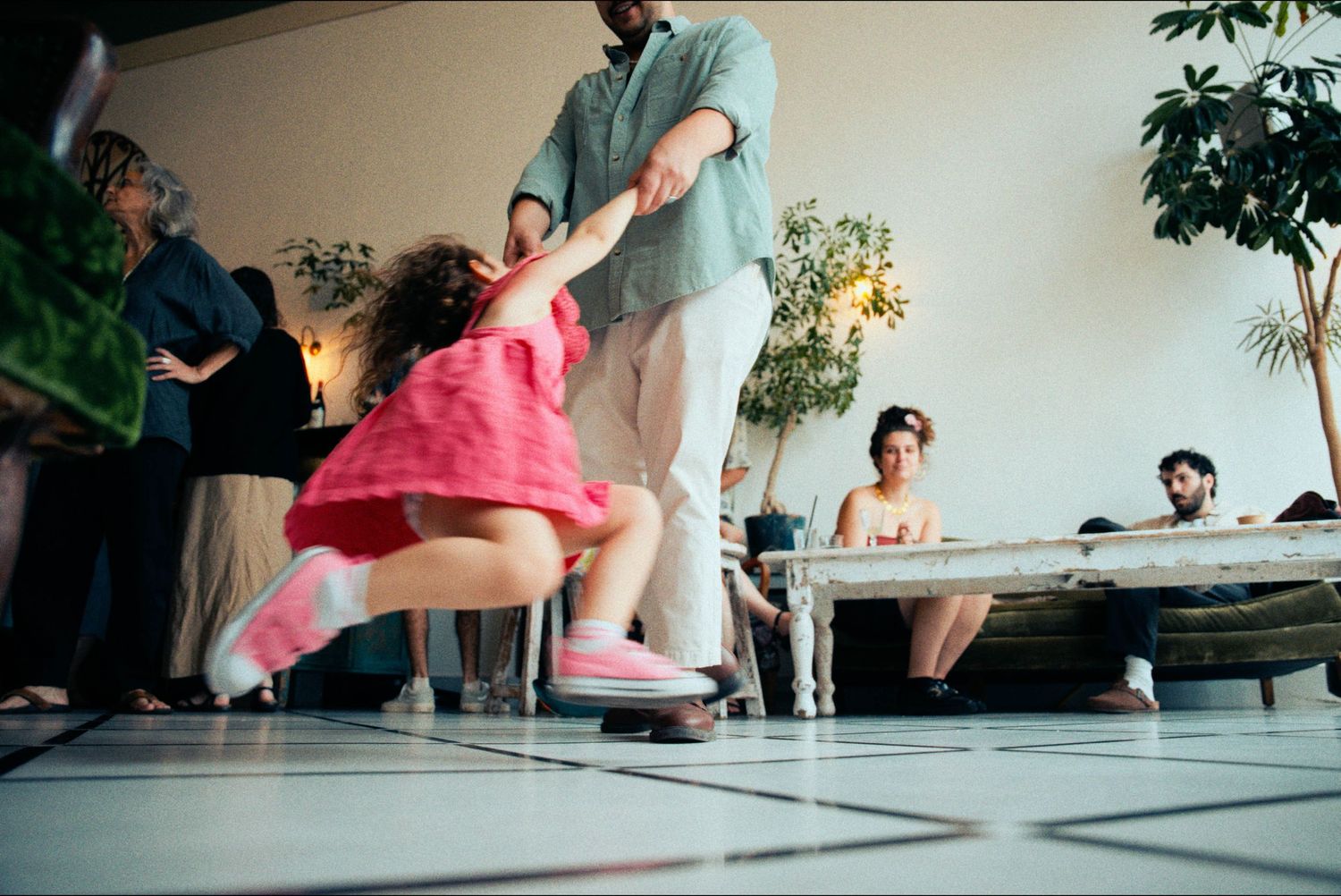 People dancing and moving on a reflective floor during a lively celebration.