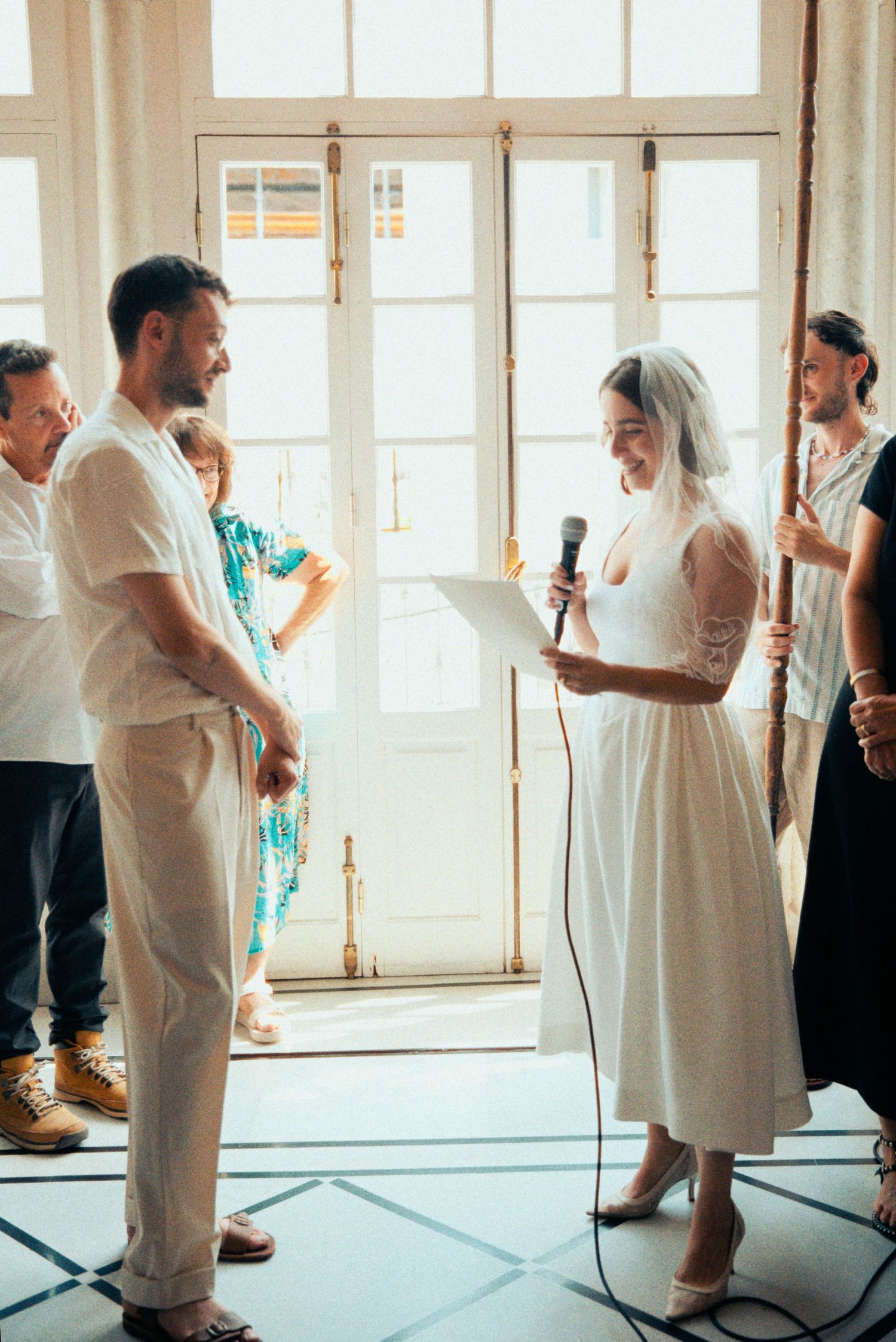 People dancing and socializing at a wedding reception in a bright room.