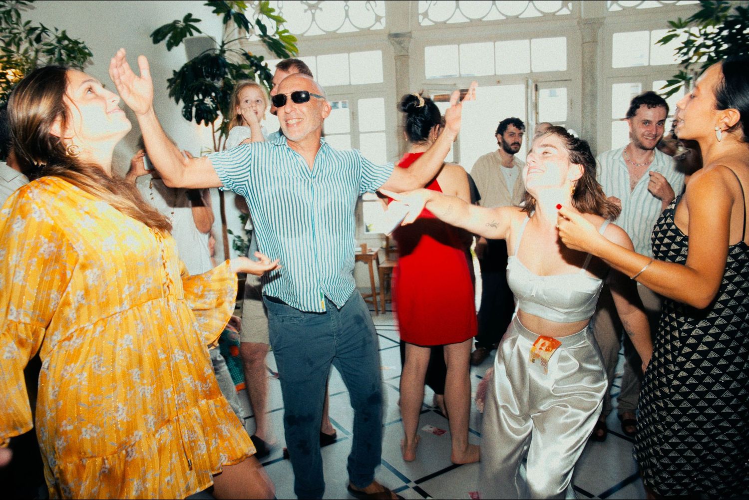 Dancers in colorful outfits enjoy themselves at a festive indoor celebration.