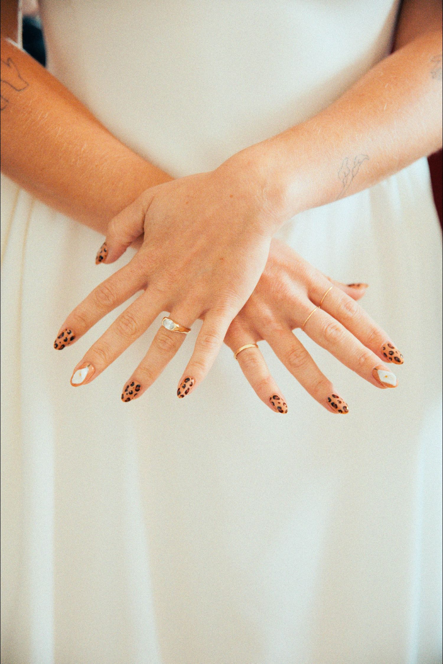 Elegant hands with decorated nails displayed against a white background.