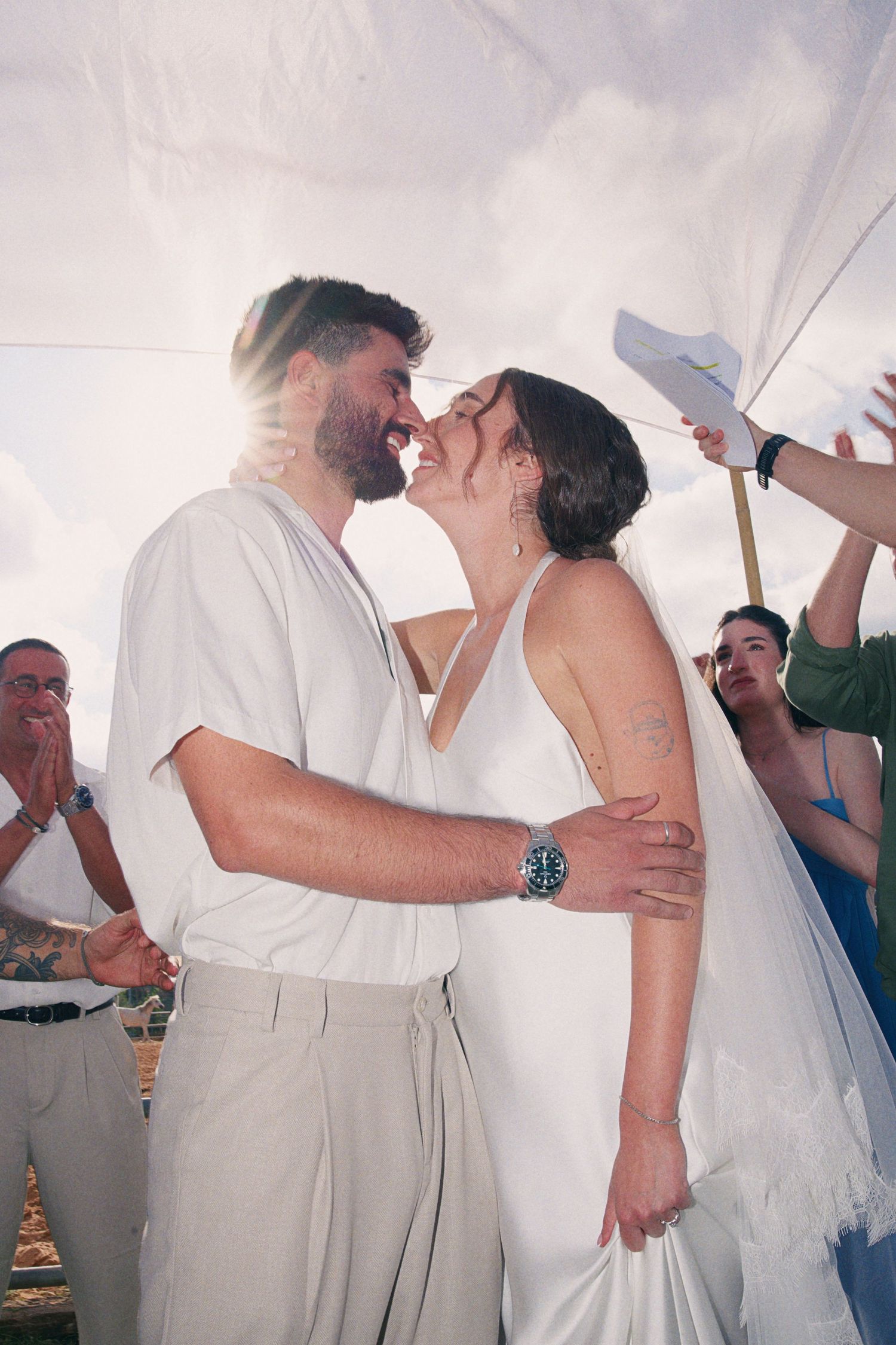Bride and groom share an intimate moment about to kiss during outdoor wedding ceremony.