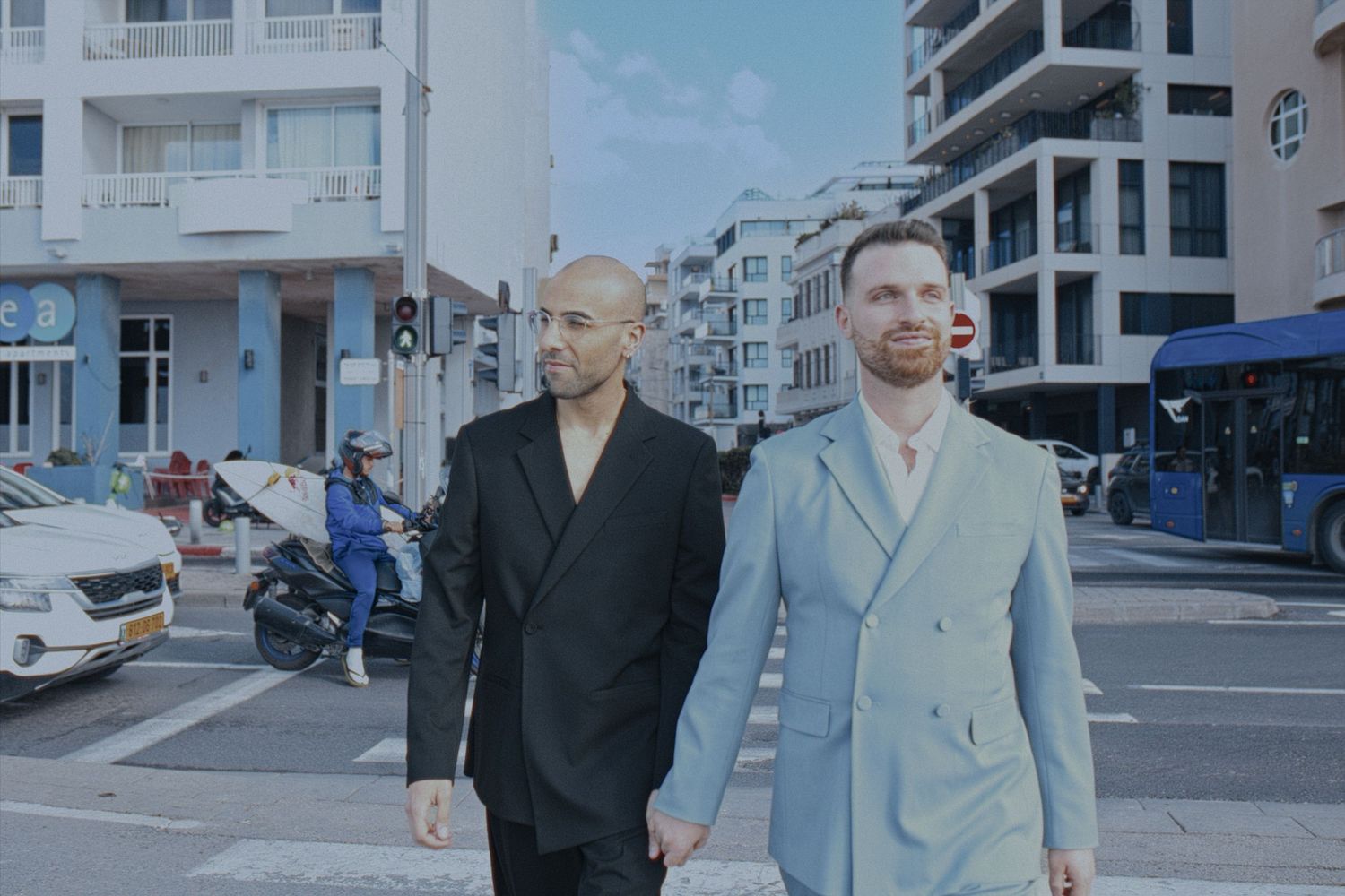 Modern urban street scene with white apartment buildings and blue sky.
gay couple in tel aviv
