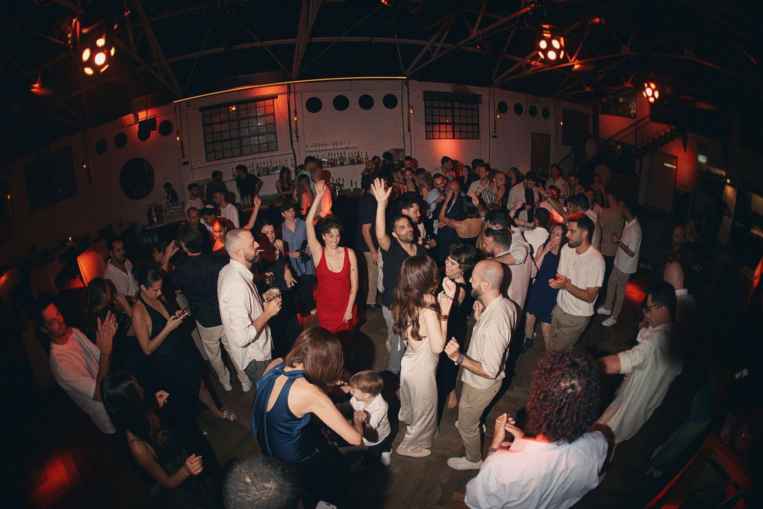 Guests dancing and celebrating on the dance floor at a vibrant wedding reception party.