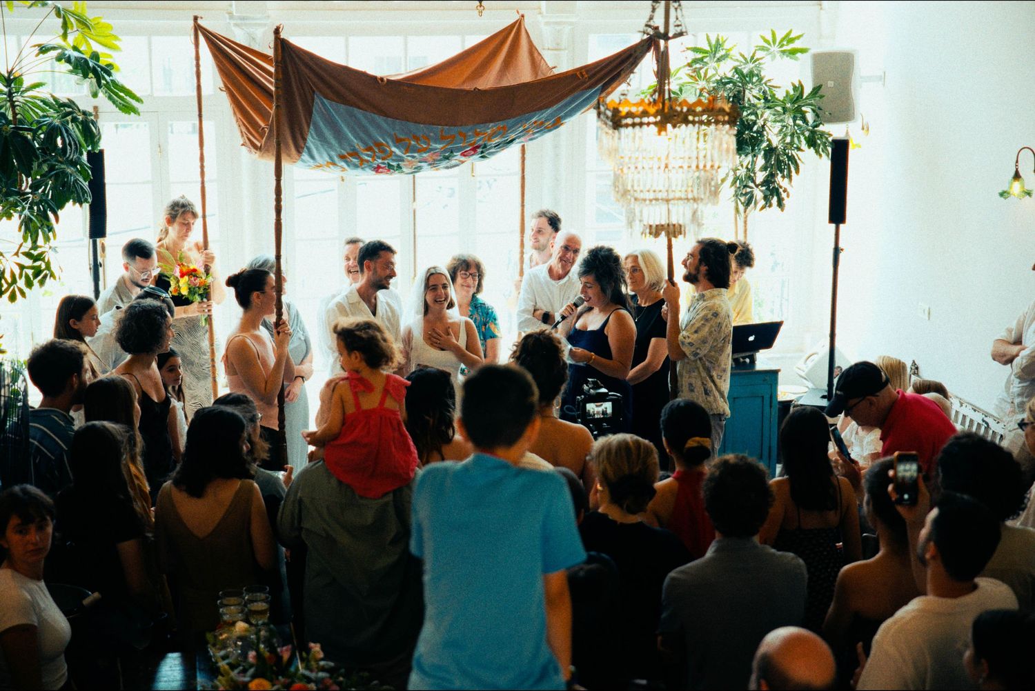 Festive indoor celebration with draped fabric decor and dancing guests.