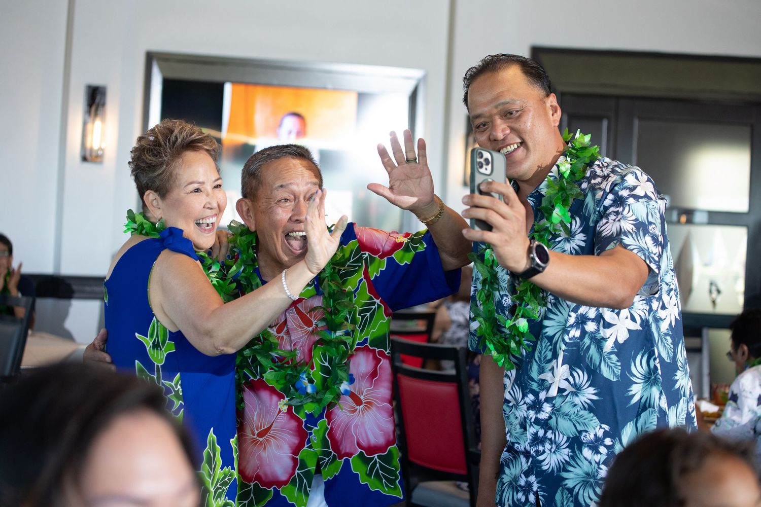 People in colorful Hawaiian shirts celebrating at a festive party.