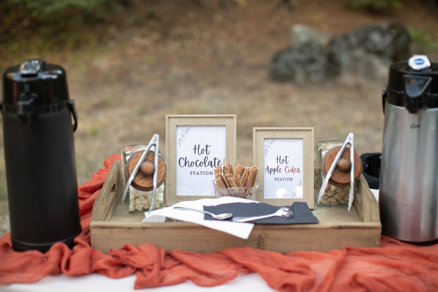 Wooden serving trays and tables with rustic decor elements arranged outdoors.