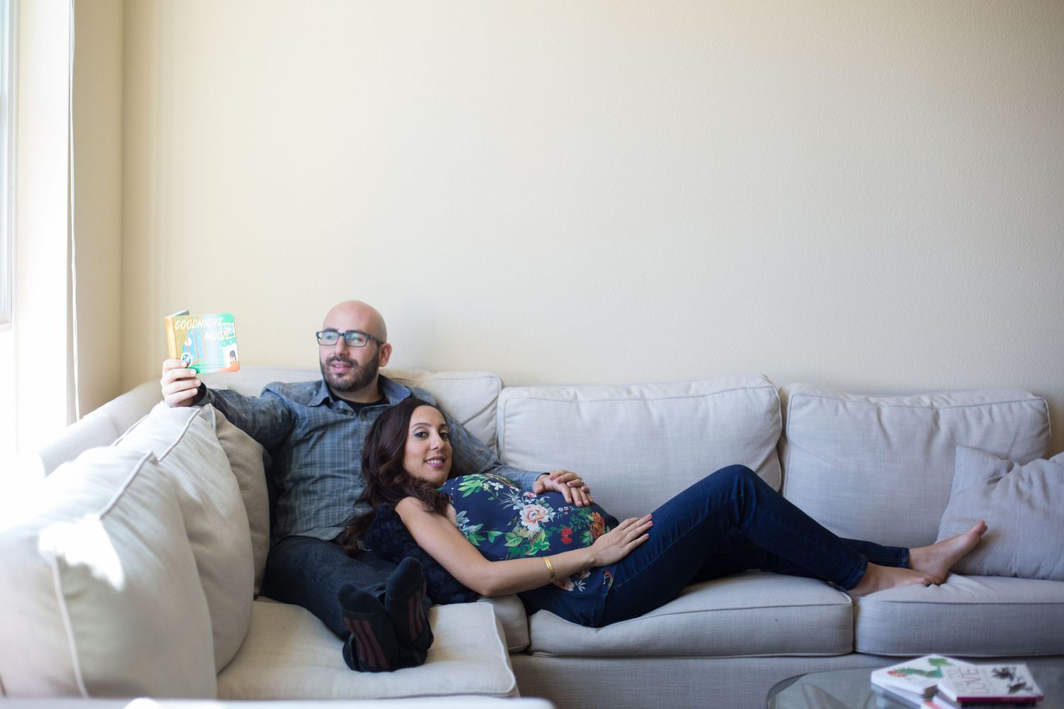 A cozy scene on a light gray sofa shows a couple relaxing against plush cushions.