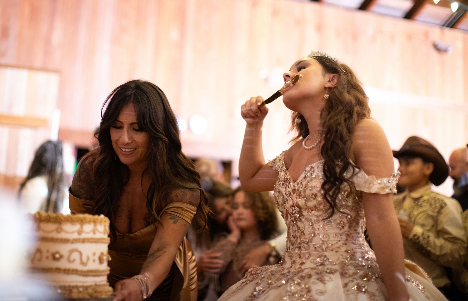 Party guests dancing enthusiastically at an elegant wedding reception with decorative lighting.