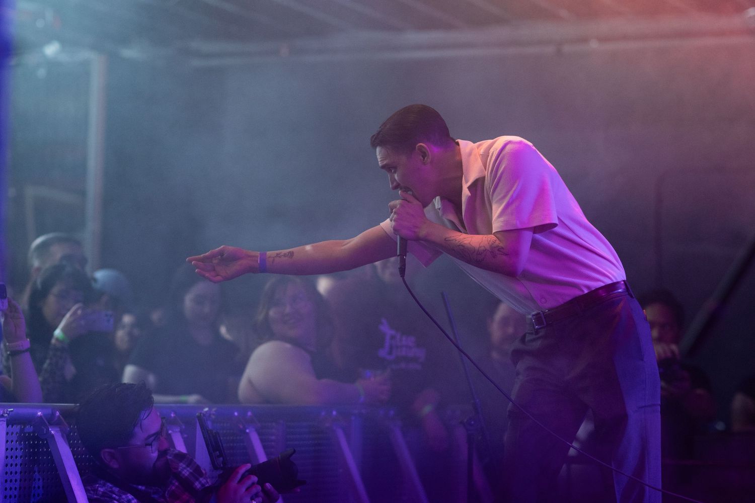 Stage performer engages with audience during energetic concert performance.