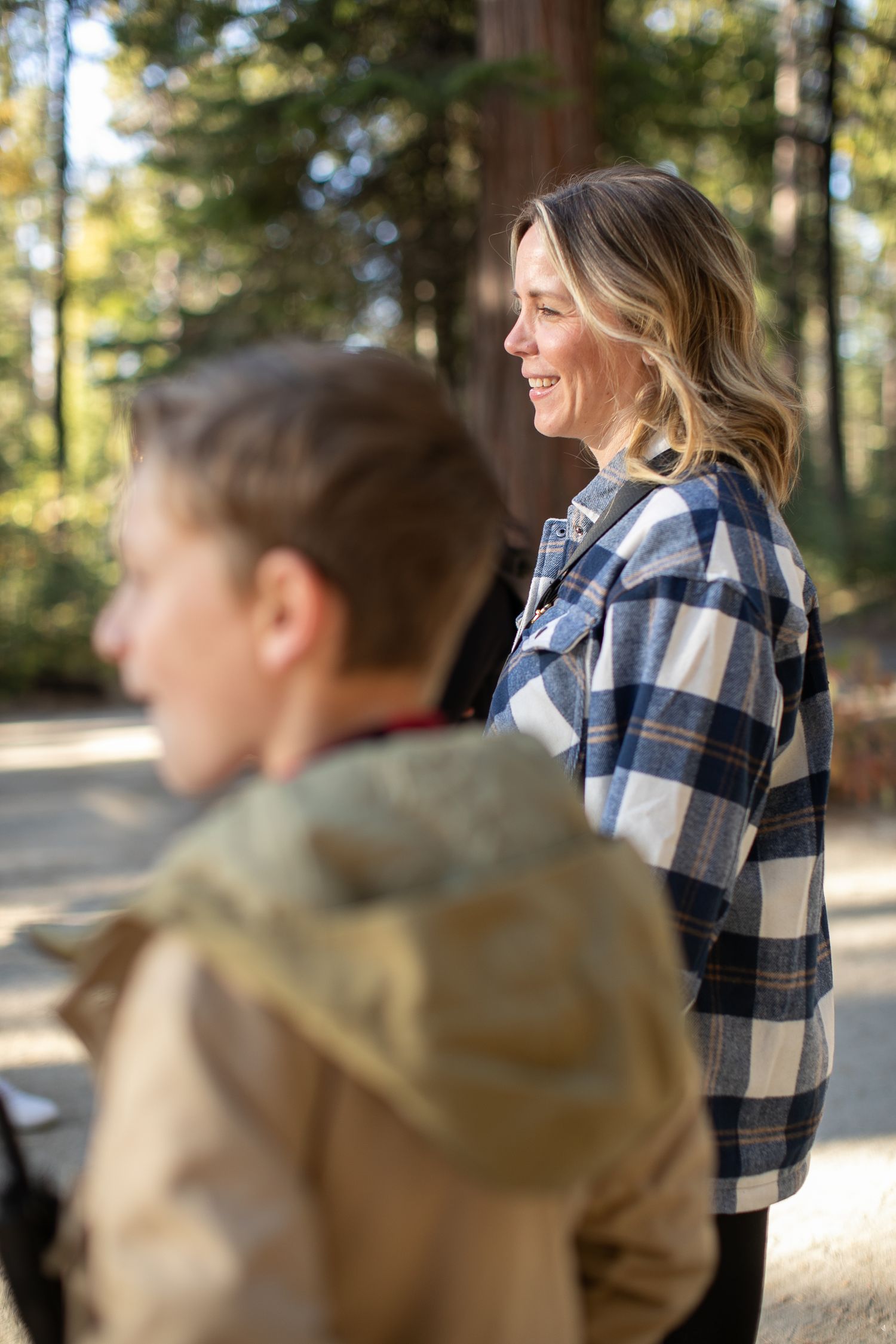 Fall outdoor gathering in a wooded setting with warm sunlight filtering through the trees.