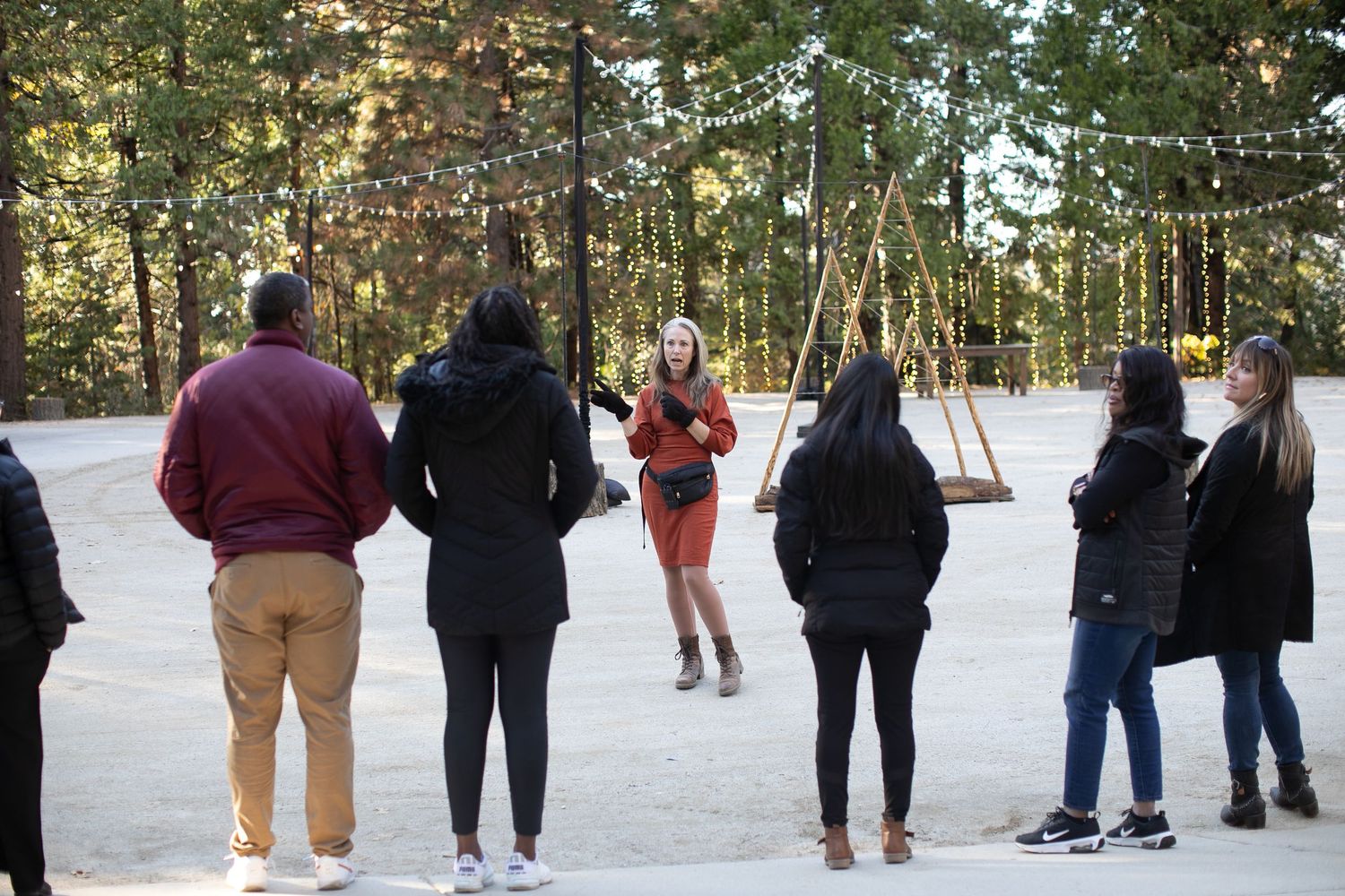 Group of people gathered outdoors for an event in a wooded area.