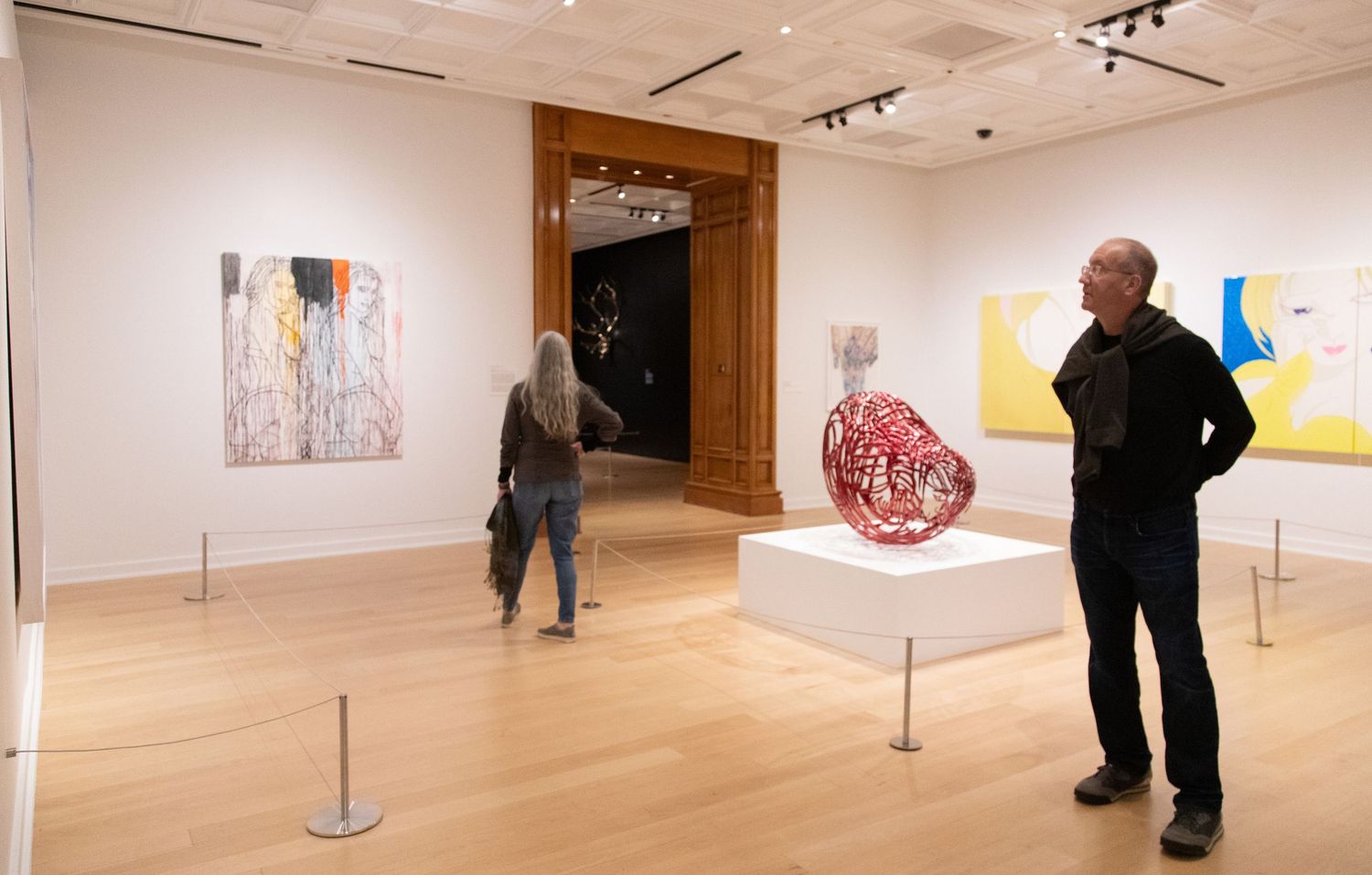 People viewing contemporary art in a modern gallery space.