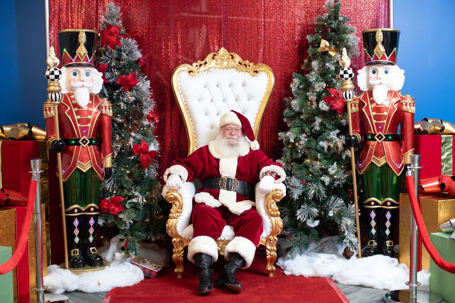 Holiday display with Santa's throne flanked by nutcracker decorations and Christmas trees.