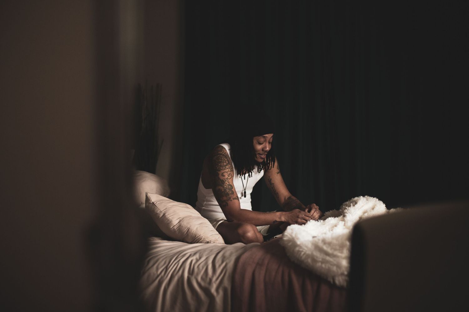 A couple shares an intimate moment on a bed while gazing at a smartphone together.