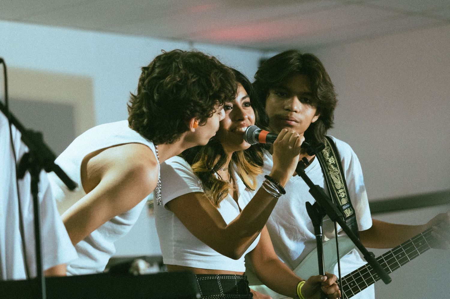 Band members play instruments during an indoor concert performance.
