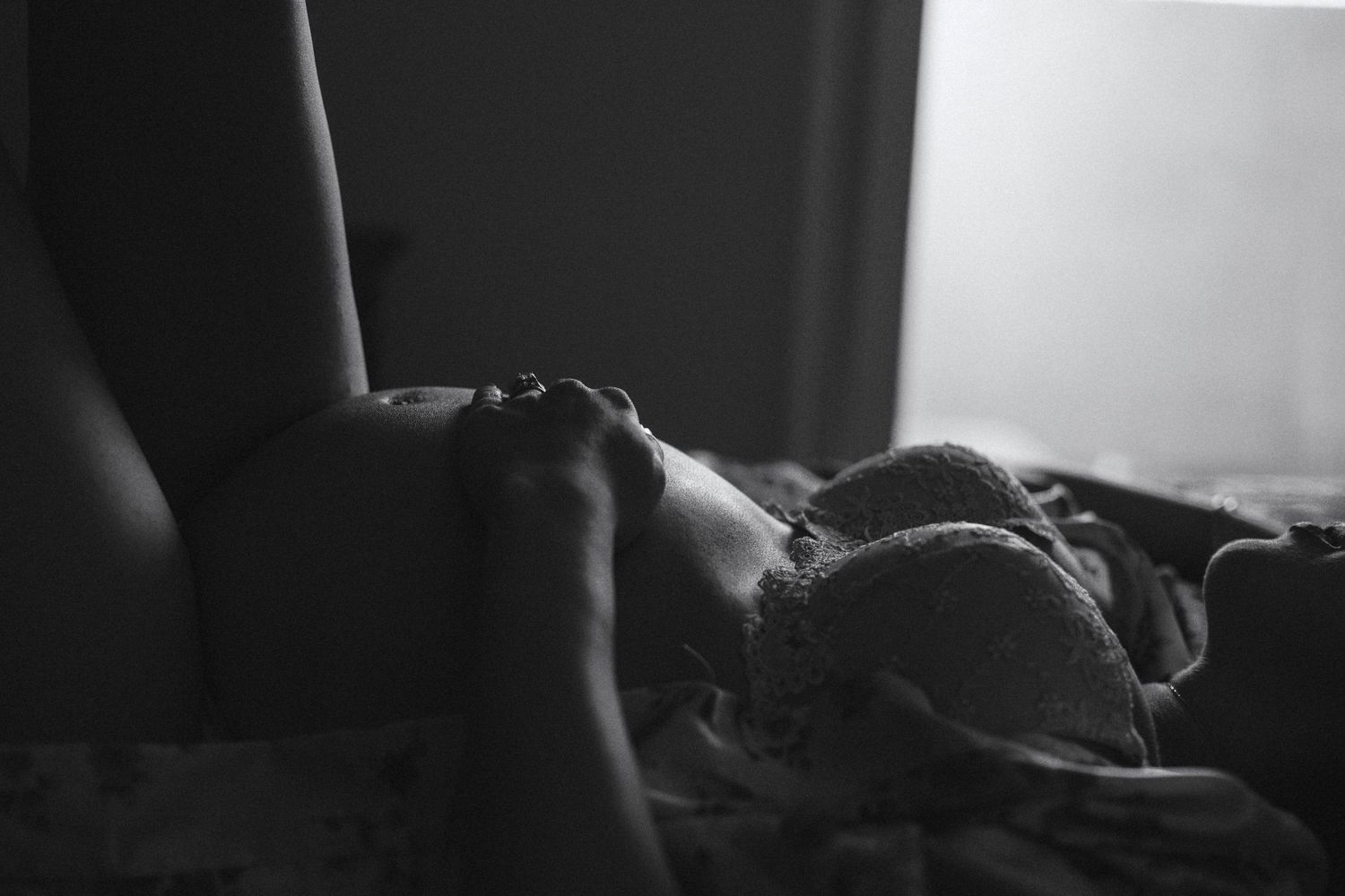 Side view of someone resting peacefully in bed with soft lighting.