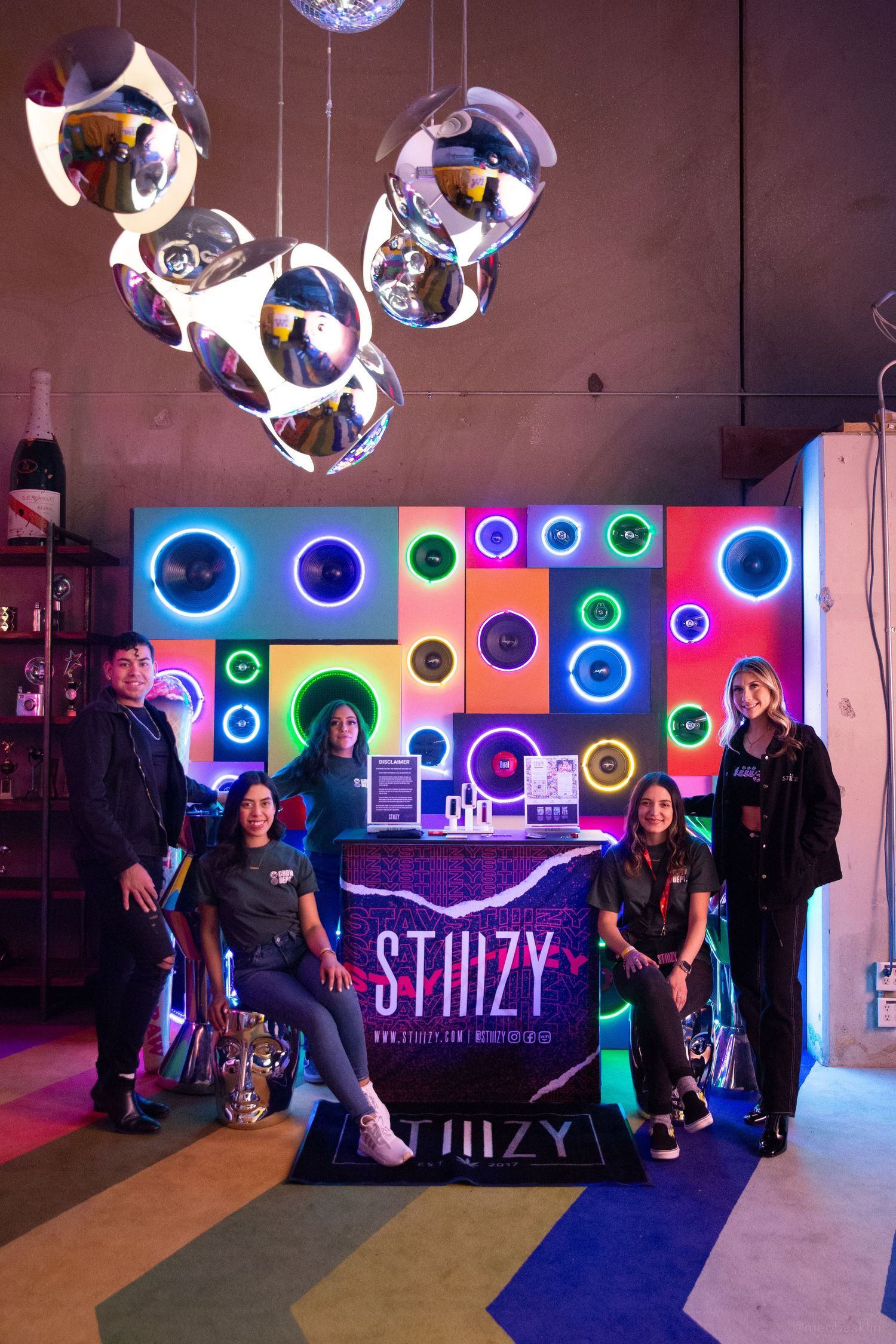 Colorful neon lighting display with circular patterns at a nighttime event venue.