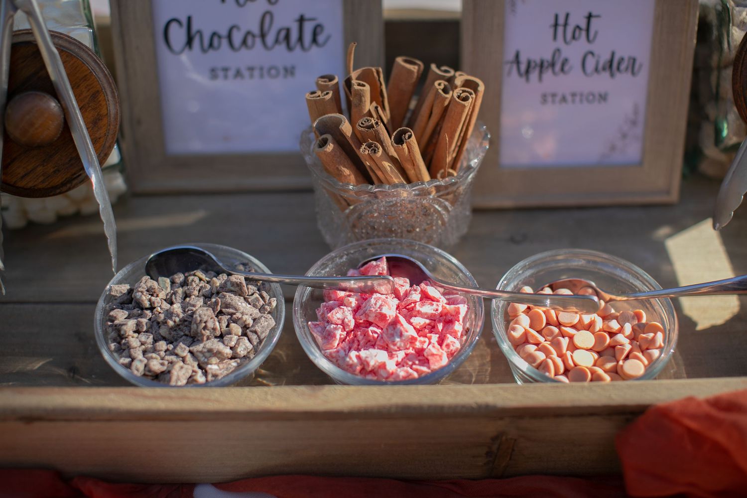 Candy station featuring three bowls of assorted treats with cinnamon sticks.
