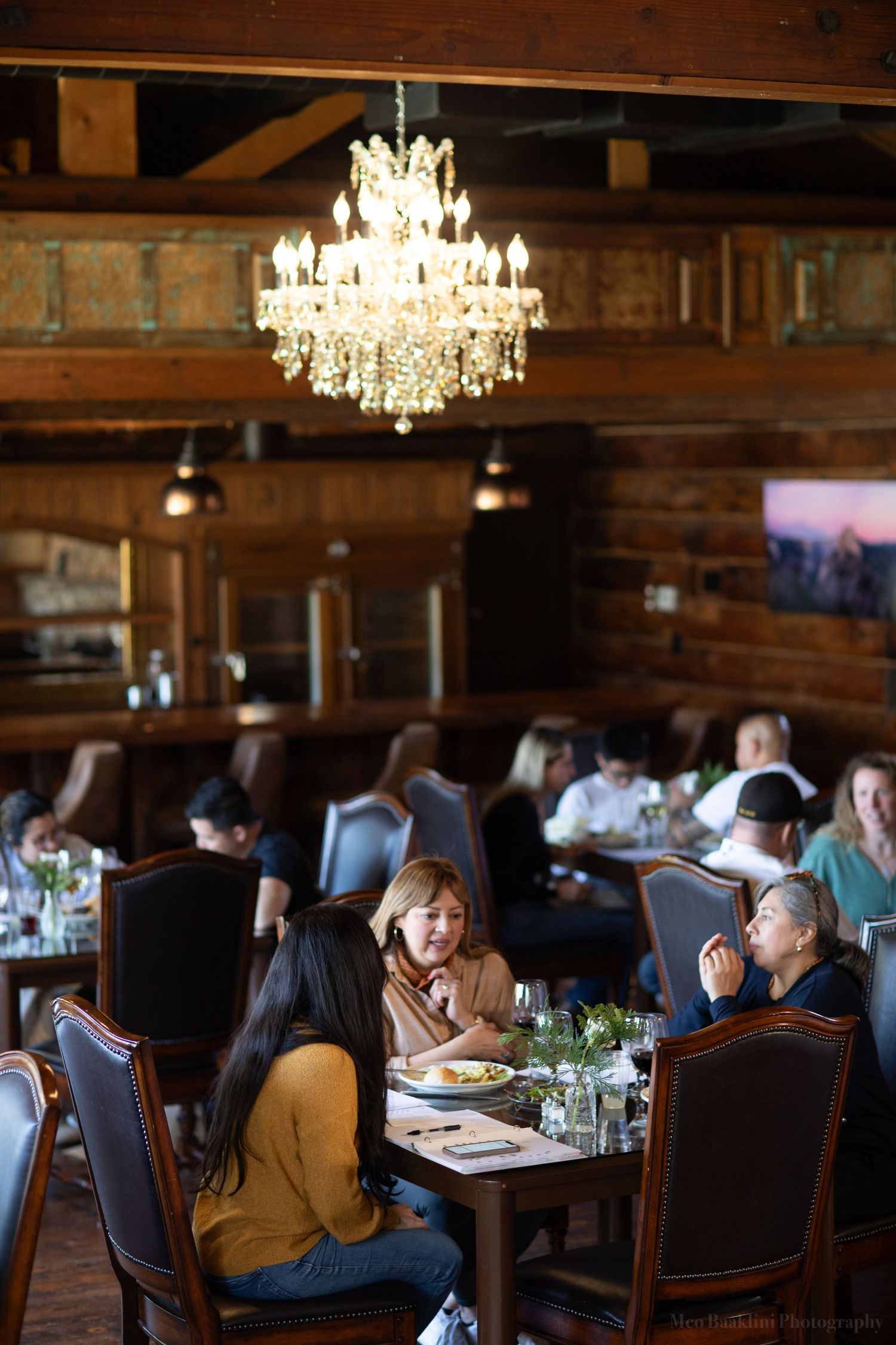 Rustic dining room with crystal chandelier and wooden beams creating an intimate atmosphere.