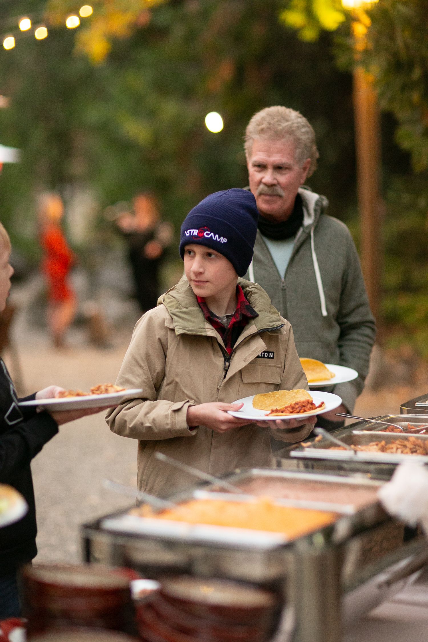 Buffet line serving food at an outdoor evening event.