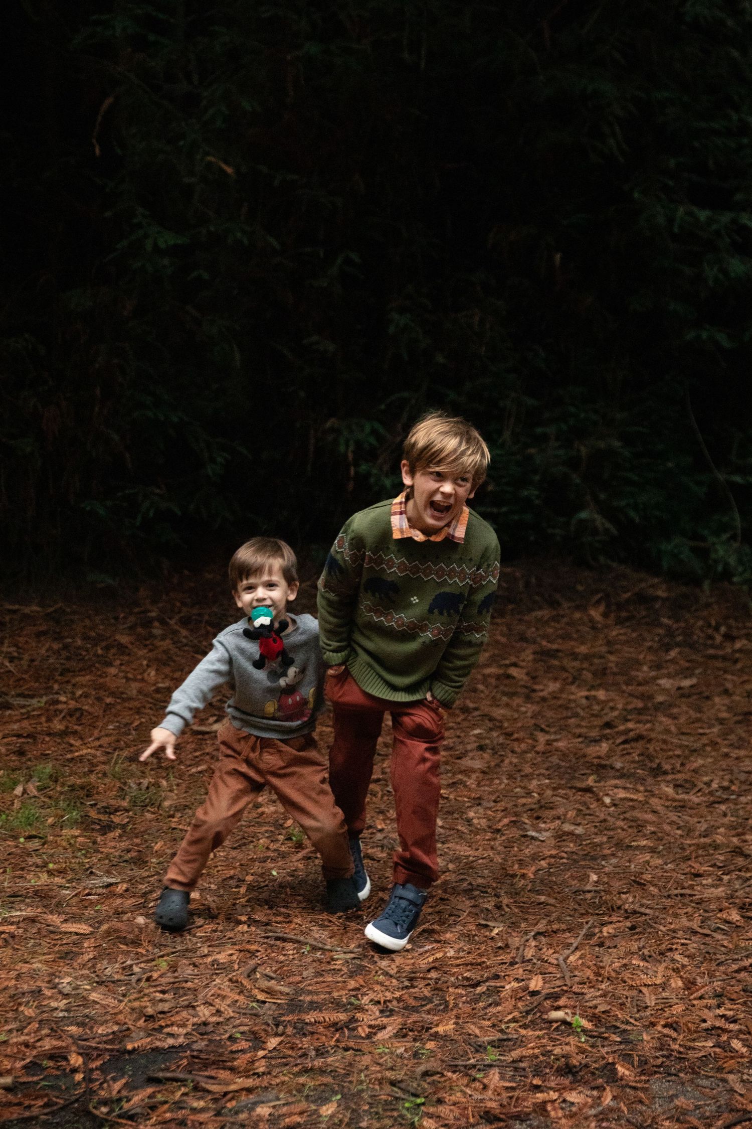 Playful sequence of children running and playing in fallen autumn leaves.