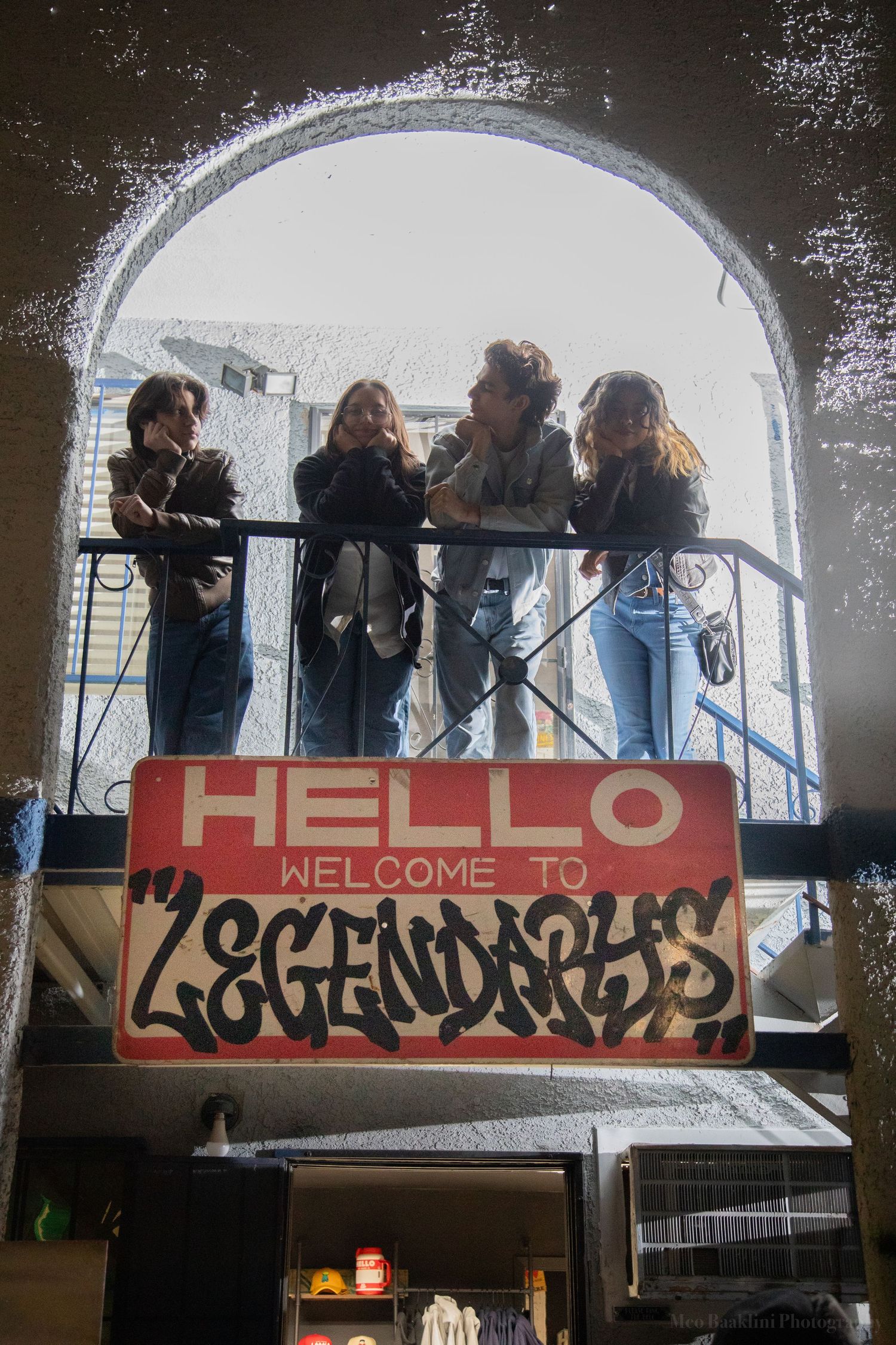 Graffiti sign reading 'HELLO WELCOME TO' displayed under an arched structure.