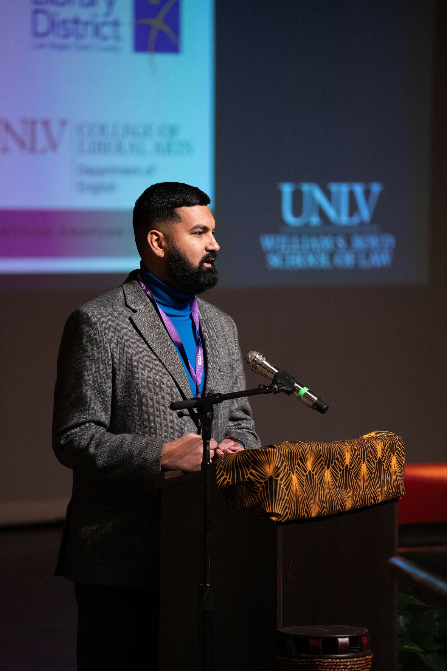 Speaker presents at podium with UNLV School of Law branding displayed on projection screen.