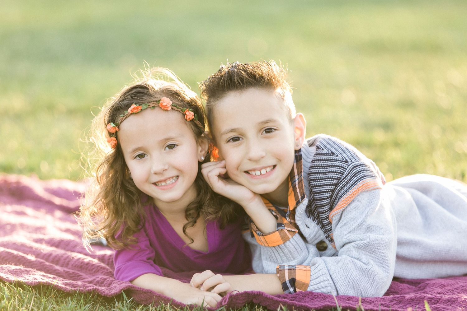 Candid lifestyle photos on a pink blanket in sunny grass.