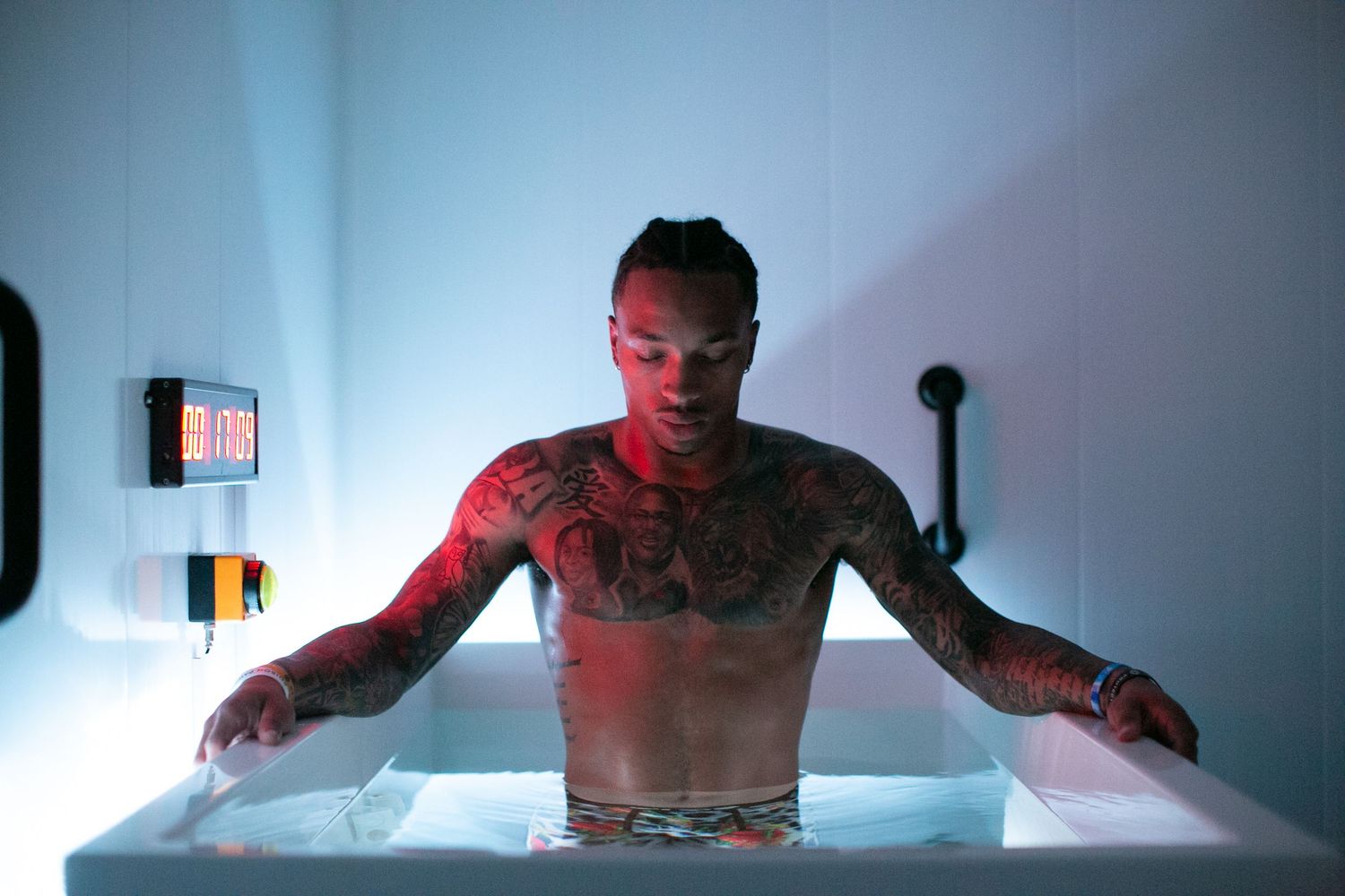 Person experiencing red light therapy treatment in a modern wellness pod.