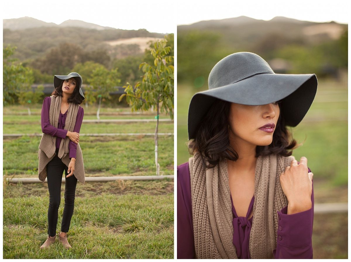 Golden hour fashion photography in field featuring burgundy accessories and wide brim hat.