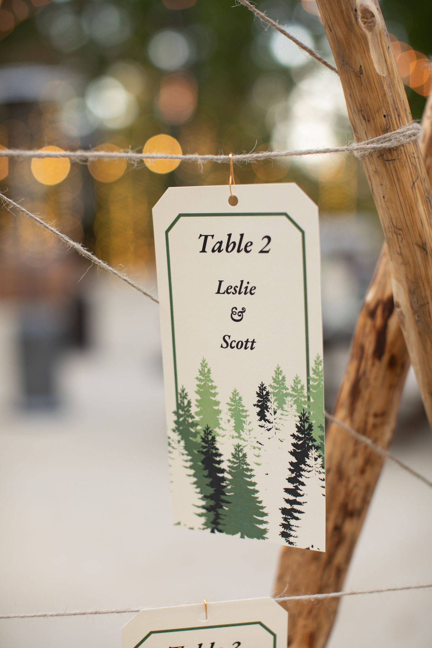 Forest-themed wedding table card with pine tree design.