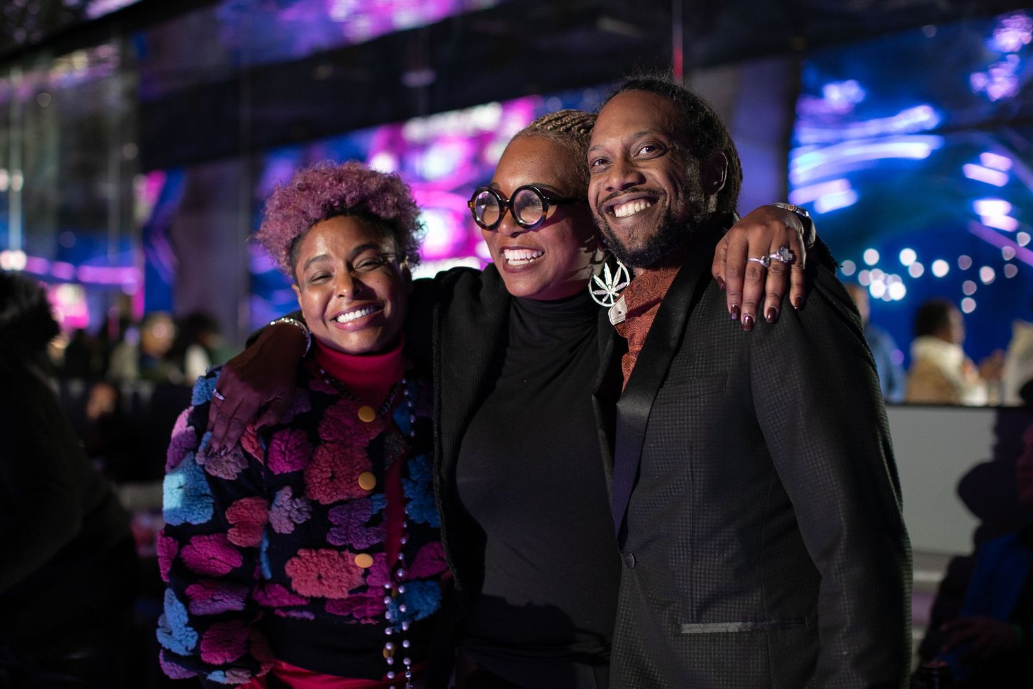 Group of people gathered at an evening event with ambient lighting and smiles.