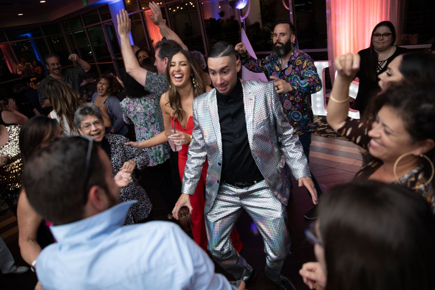 Energetic dance party scene with guests celebrating on a crowded dance floor.