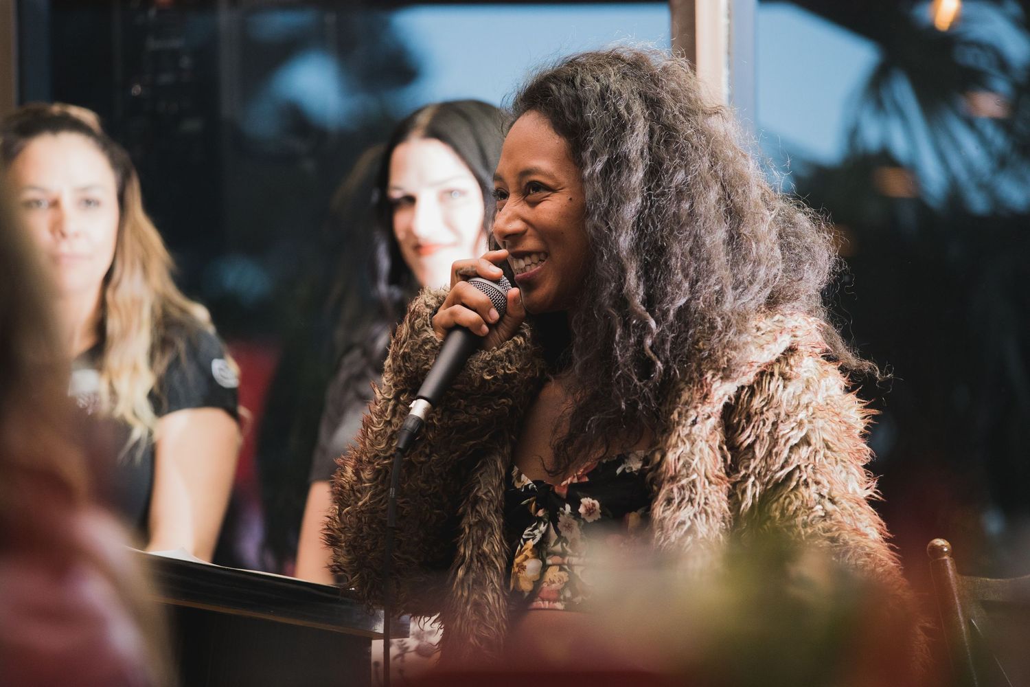 A performer singing into a microphone during an outdoor event.