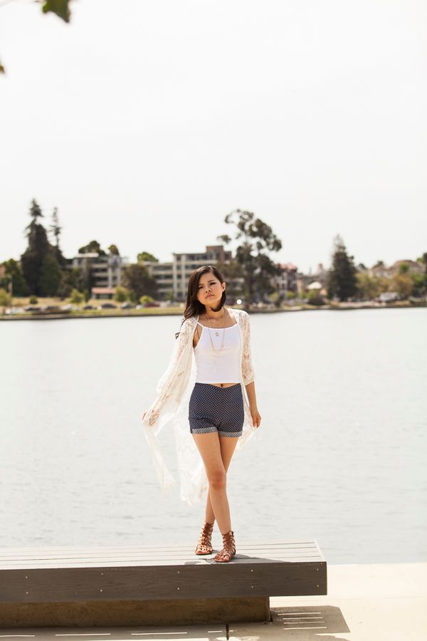 Playful poses on a concrete pier overlooking calm waters.