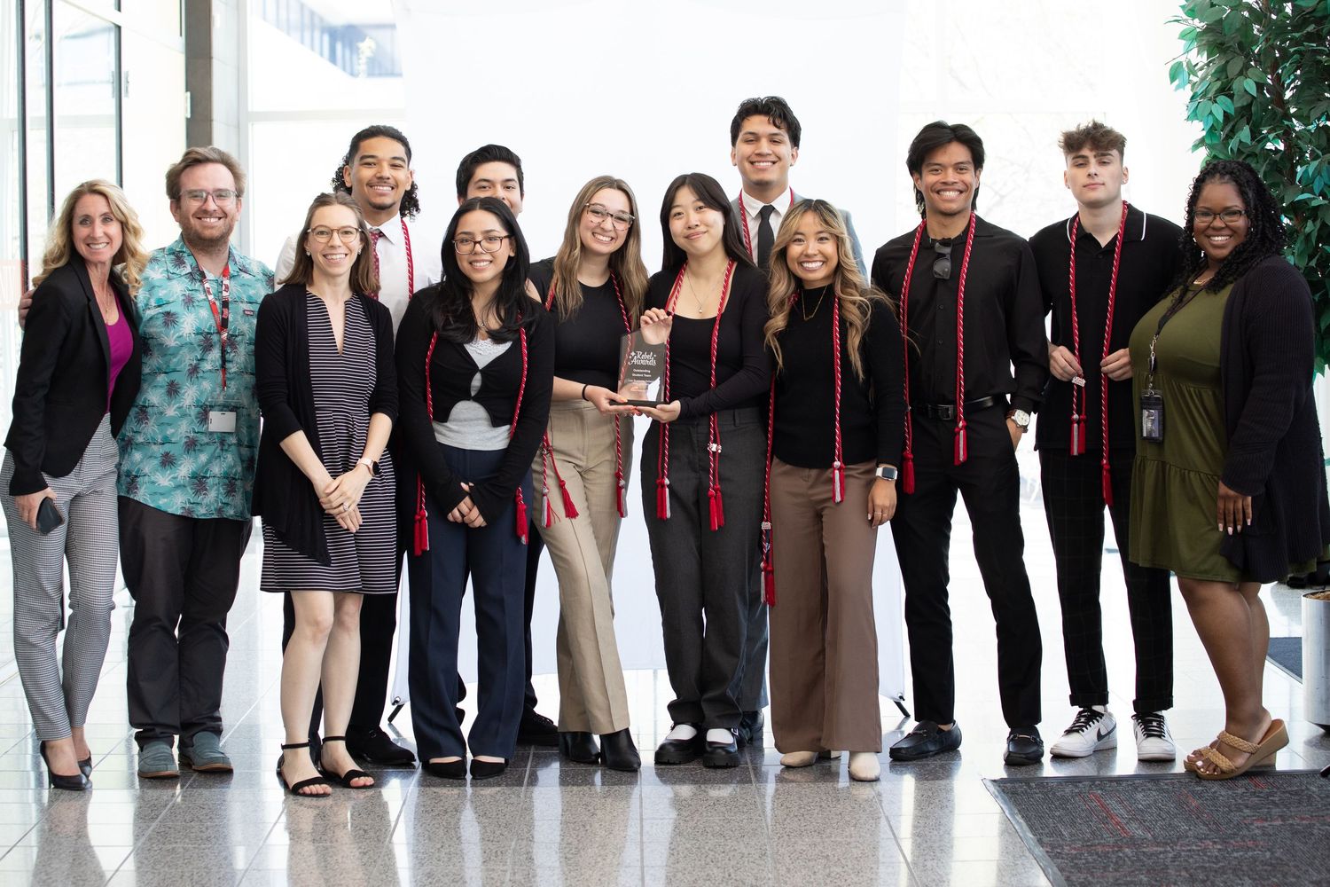 Group photo of diverse students and faculty members standing together in academic setting.