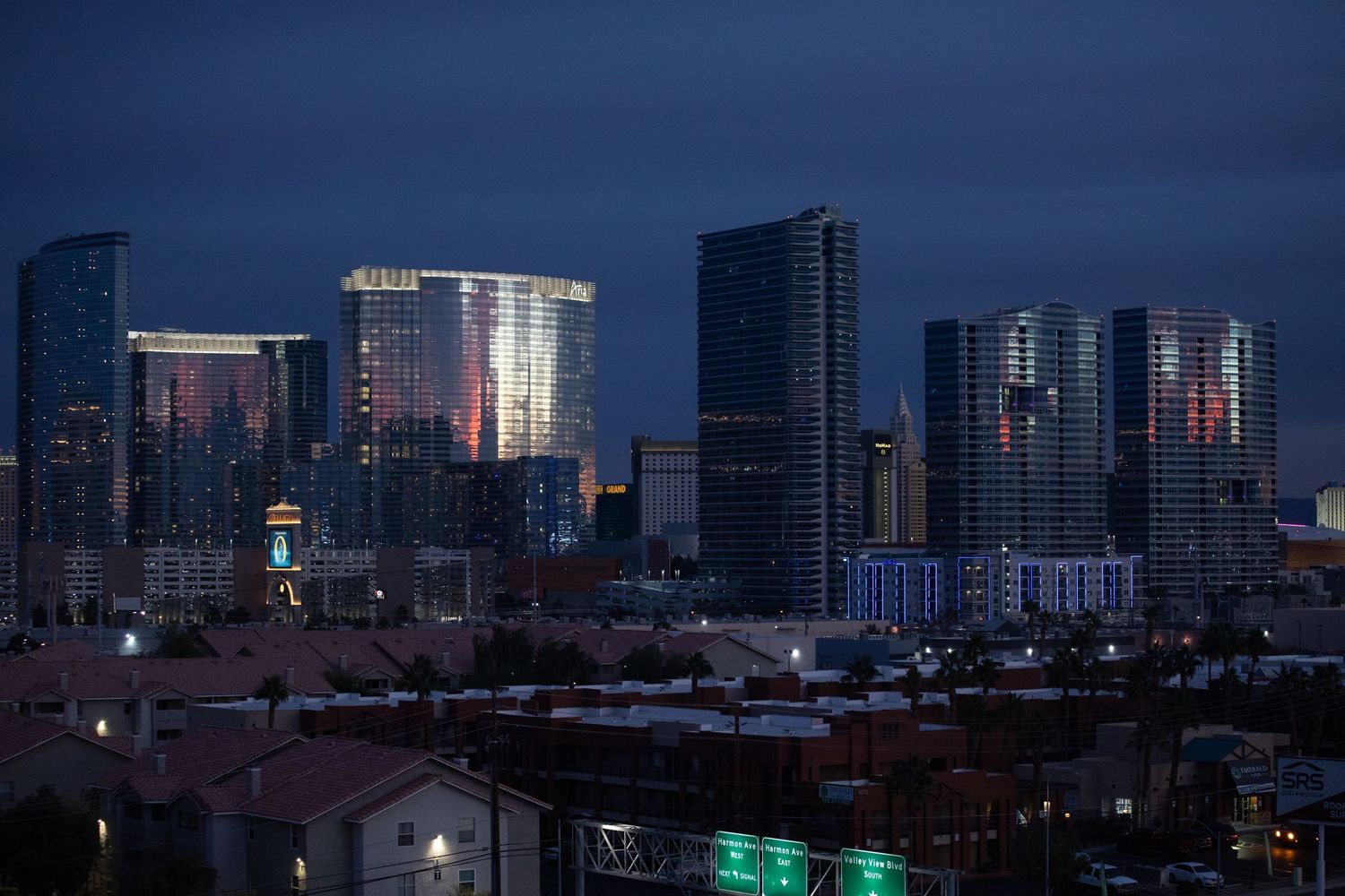 Panoramic cityscape view of urban buildings and skyscrapers at dusk.