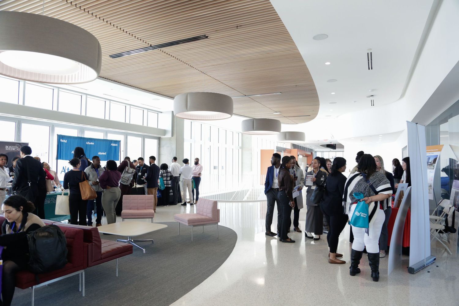 Corporate gathering in modern white office space with curved architectural details.