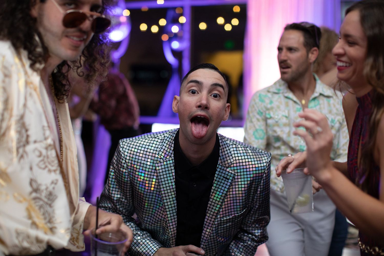 Candid party shots of guests laughing and enjoying themselves under colorful lighting.